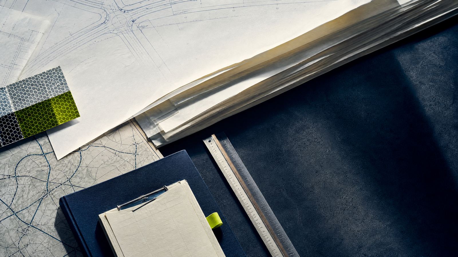 Technical reference materials and highway hardware samples arranged on a desk.